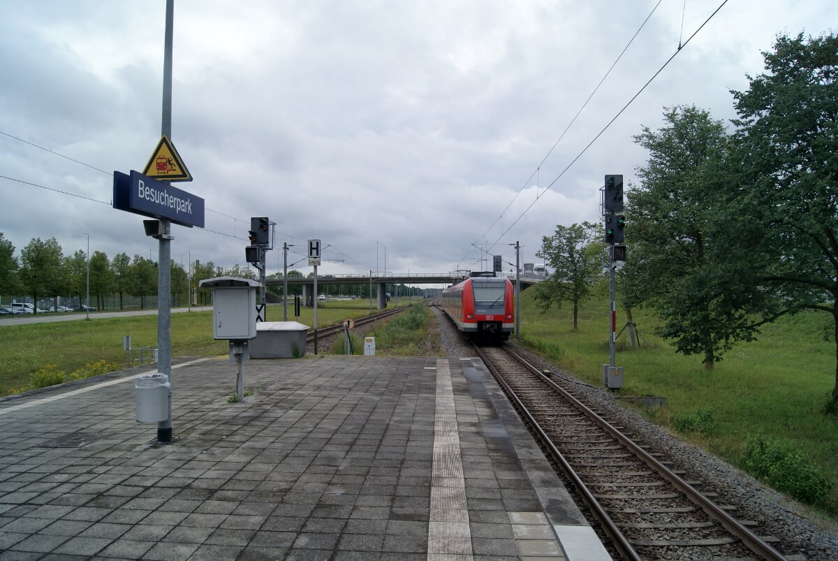 Eine S-Bahn fährt von der Haltestelle Besucherpark in Richtung Straßenüberführung.